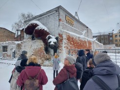 Die CCC-Projektpartner*innen besichtigen Riga. Es liegt viel Schnee. Auf einer Mauer klettert die überdimensionierte Figur eines Fuchses.