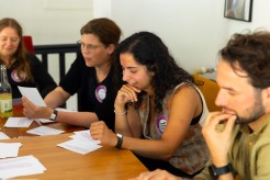 Ghader Al Holu sitzt mit anderen Teilnehmenden auf dem Festival Memory Matters am Tisch.