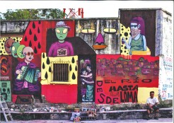 Graffiti an einer Hauswand in Mexiko mit alienähnlichen Personen, die Musikinstrumente spielen oder tanzen. Unten in der Ecke steht "Desde el río hasta la soma".