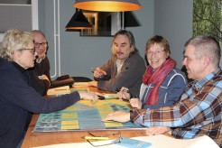 5 Personen sitzen um einen Tisch und machen eine Gruppenarbeit mit Kärtchen und Postern.