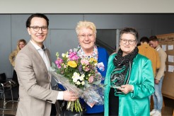 Felix Schartner-Giertta (links) vom CBSS und BSR Cultural Pearls überreicht Annette Wiese-Krukowska (Mitte) vom Referat Kreative Stadt Kiel und Bürgermeisterin Renate Treutel (rechts) einen Blumenstrauß und einen Award.