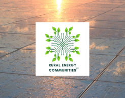 Im Hintergrund ist eine Photovoltaikanlage, in der sich der Sonnenaufgang spiegelt. Darauf ist das Logo von Rural Energy Communities LV.