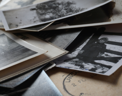 Schwarz-Weiß Fotos liegen auf einem Haufen zusammen. Es scheinen ältere Bildaufnahmen zu sein.