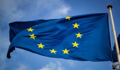 Eine wehende Europa-Flagge vor blauem Himmel.